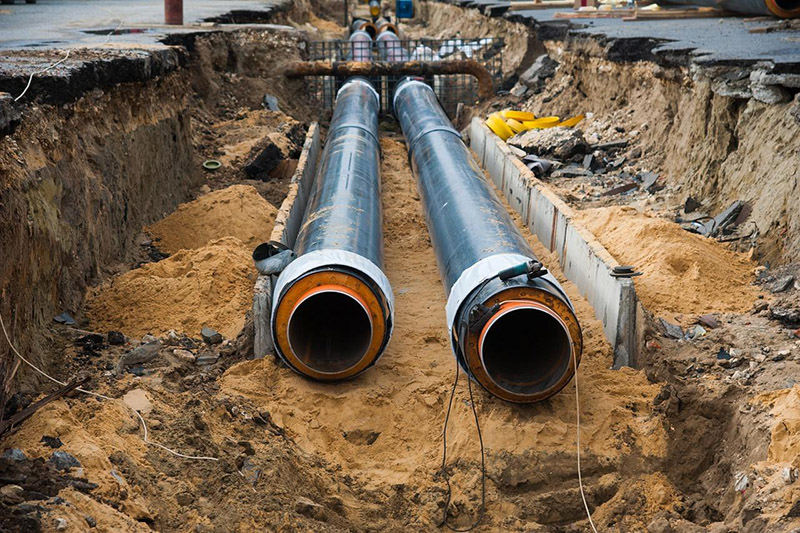 Underground utility pipes installed in an excavated trench at a construction site